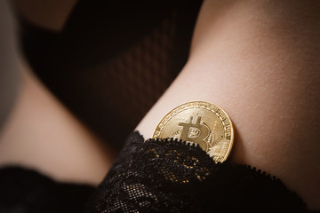 Bitcoin gold coin on in hands of sexy girl in underwear, concept shadow economy initial world...