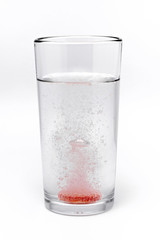 soluble effervescent multivitamin in a glass glass with water on a white background	