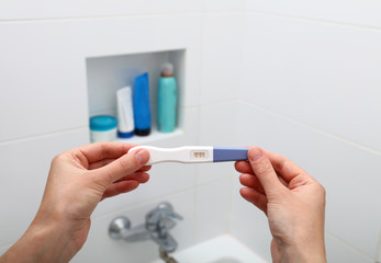 Woman hands holding positive pregnancy test
