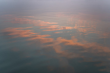 Tonos rosados reflejados sobre el agua del río Ganges (Varanasi) durante el amanecer.