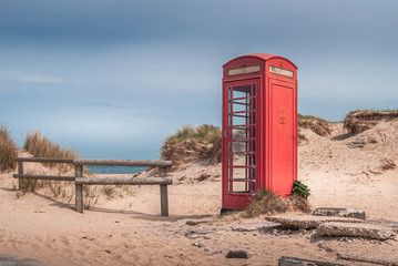 The iconic and weathered red telephone box on Shell Bay beach, Studland, near Sandbanks, Dorset, UK
