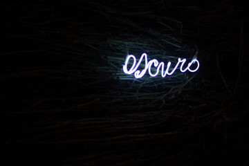 Palabra oscuro escrito con luz sobre un fondo oscuro escrito en Italiano / Español.