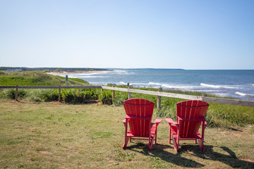Beautiful chairs and ocean on a sunny day at Cavendish Beach in Prince Edward Island, Canada