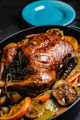 Whole Duck Roasted with Oranges, Carrots and Potatoes on Dark Stone Background