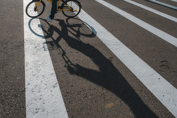 A man on a bicycle crosses the road at a pedestrian crossing
