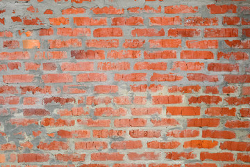 Red brick wall background. Wall of brick and cement close-up. The texture of the new brick wall is orange.
