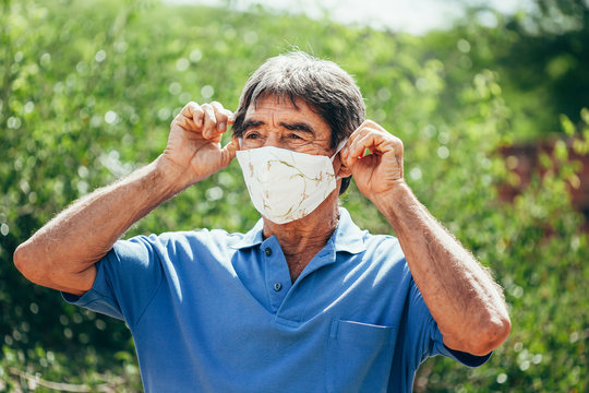 Portrait Of Elderly Man Wearing Homemade Protective Mask Sunning During Quarantine. Coronavirus, Covid-19 And Pandemic Concept