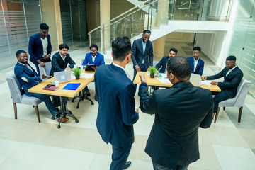 international group of nine african american and indian people having a rest after brain storm in big office