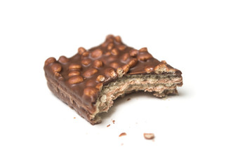 Closeup of crunched chocolate bar with puffed rice on white background