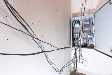 Voltage switchboard with circuit breakers are in the electric box and some electrical cables. Concept of temporary switching-on and connecting electricity in the house that is under construction or