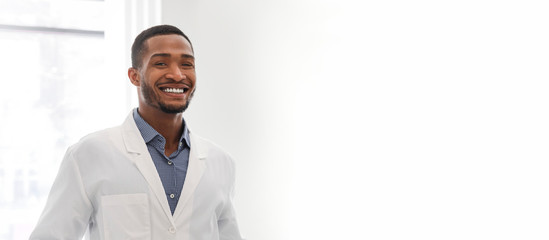 Portrait of young black dentist posing in clinic