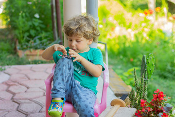 The child spins spinner. Little boy plays with a spinner outdoors.