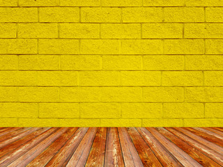 Brick wall with regular shapes and a rough surface. Empty yellow background with floor