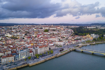 Fototapeta premium Coimbra drone aerial city view at sunset with Mondego river and beautiful historic buildings, in Portugal
