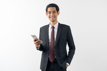 happy young asian businessman smiling and holding a smart phone in formal suit isolated on white background.