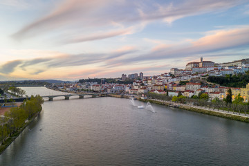 Fototapeta premium Coimbra drone aerial city view at sunset with Mondego river and beautiful historic buildings, in Portugal