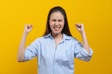 Excited winner woman scream after received good news isolated on yellow background in studio.