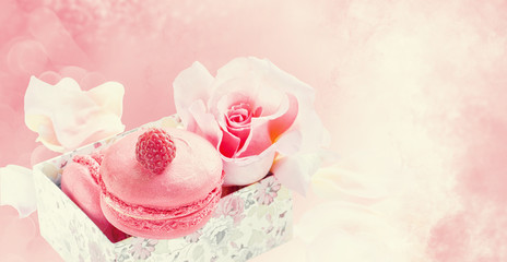 Raspberry and strawberry pink macaroons on pastel valentine decor and rose flowers soft background, shallow DOF. Gentle macaroons on table on light background.