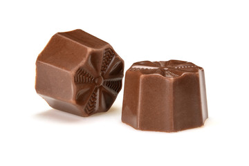 Chocolate pralines. Two dark chocolate bonbons with toffee fillings, macro close-up isolated on white background.