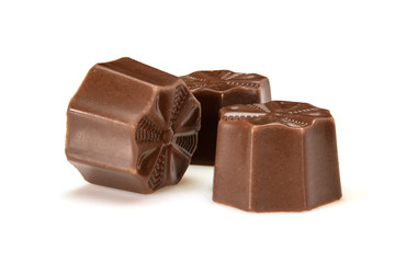 Chocolate pralines. Three dark chocolate bonbons with toffee fillings, macro close-up isolated on white background.