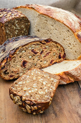 Fresh bread in the assortment of home-made sourdough. Bread with wheat grains and seeds on a wooden Board. Close up