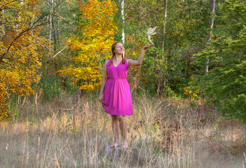 Beautiful girl staring at fairies in a magical forest . Fantasy concept. girl and fairy in the...