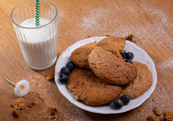 caramel dulce de leche biscuits with glass of milk on wooden table 