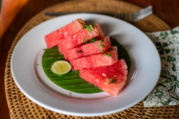 Balinese breakfast served in a white plate with watermelon and lemon piece