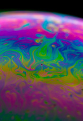 Fototapeta na wymiar Psychedelic abstract planet from soap bubble, Light refraction on a soap bubble, Macro Close Up in soap bubble. Rainbow colors on a black background. Model of Space or planets universe cosmic galaxy.