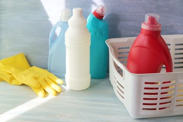 Liquid detergents in plastic bottles, rubber gloves for cleaning the house on a wooden table, home delivery