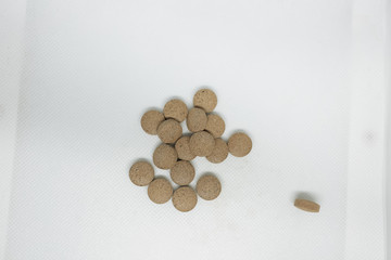 medication for coronavirus. the coronavirus epidemic. propolis in tablets. brown pills on a white background