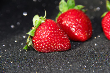 Strawberry on a black background. Brilliant background with berries.