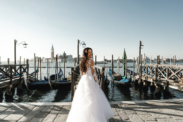 beautiful bride dressed in a wedding dress and stands near the pier,fashionable wedding dress,smiling bride in dress,