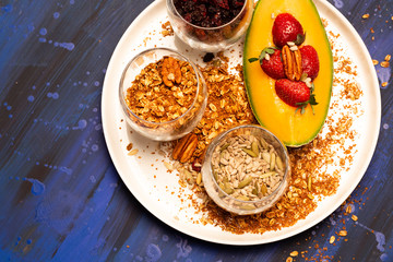 Melon pieces, on blue table with blue plate and seeds.