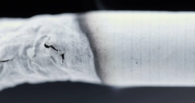 Smoldering cigarette on a black background. Smoke from a cigarette	