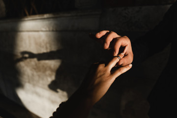 man proposes a woman to marry,close-up of the hand of the groom who dresses the wedding ring on the bride’s finger,ring exchange wedding ceremony,hands of the groom with the bride close-up
