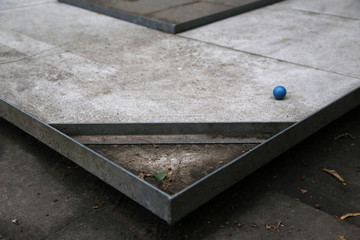 Detail Aufnahme vom Minigolf im Sommer mit einem blauen Ball auf Grauen Untergrund	