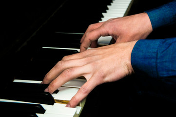the musician accompanies the piano. man plays a musical instrument. male fingers on the keys