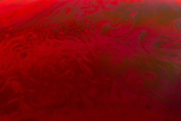 abstract background of iridescent paints in red colors