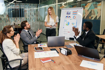 Friendly colleagues are discussing their joint business plan during working day. © gorynvd