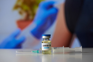 A brand new vaccine against coronavirus. Covid-19 vaccine on the table near a syringe in the hospital. Antiviral drug.