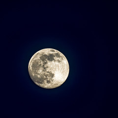 A large full moon in a dark sky