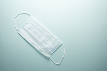 Disposable medical mask on a light background with place for text.