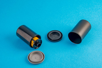 Old photo film with film can on blue