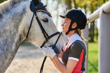 Girl horse rider stroking a horse. Equestrian theme