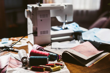 Workplace of a seamstress. Still life with a sewing machine, threads, patterns. The room of an elderly woman. Clothing design. Sewing at home.