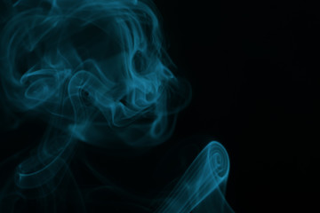 Abstract overlay blue  smoke in shape of skeleton head on black background