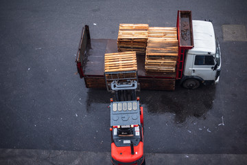 Forklift loading a pallet to the truck. Forklift lowering pallet from the van. Pickup truck...