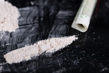 Fototapeta premium Drugs and money scattered on the glass. Illegal drugs at the crime scene.
