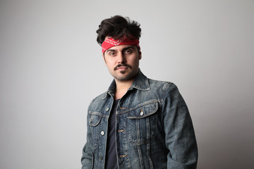 Headshot of serious stylish hipster with confident expression, wears denim jacket, isolated over white background.